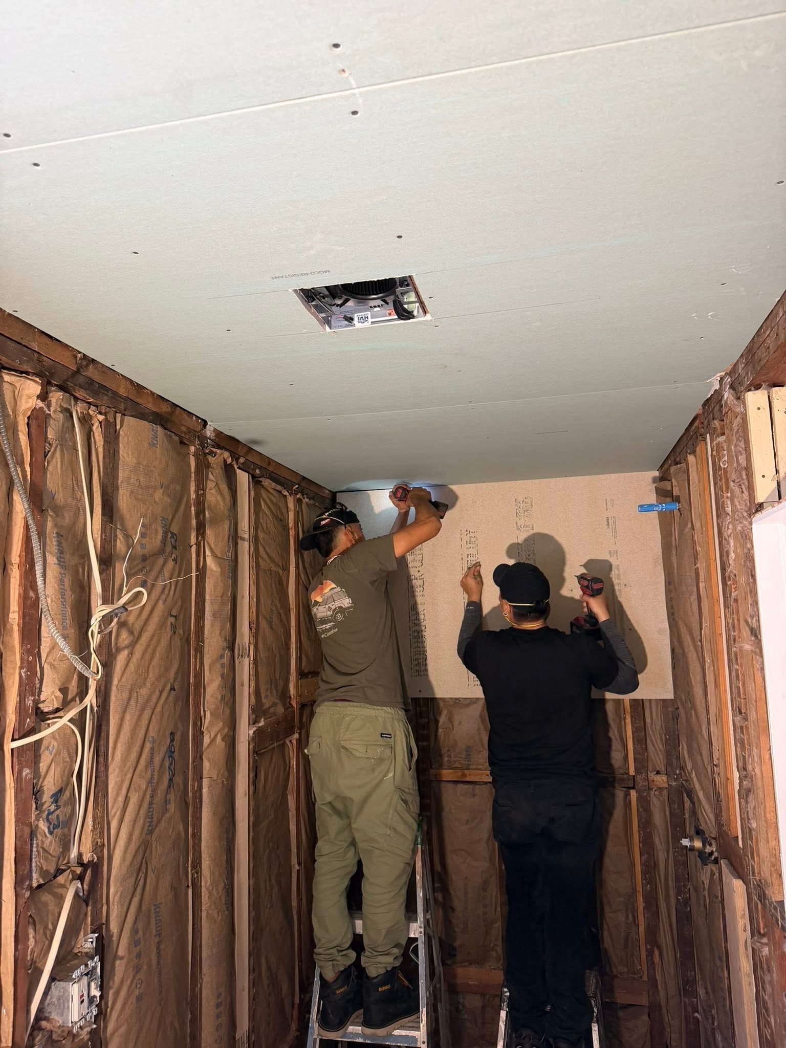 Team installing drywall ceiling