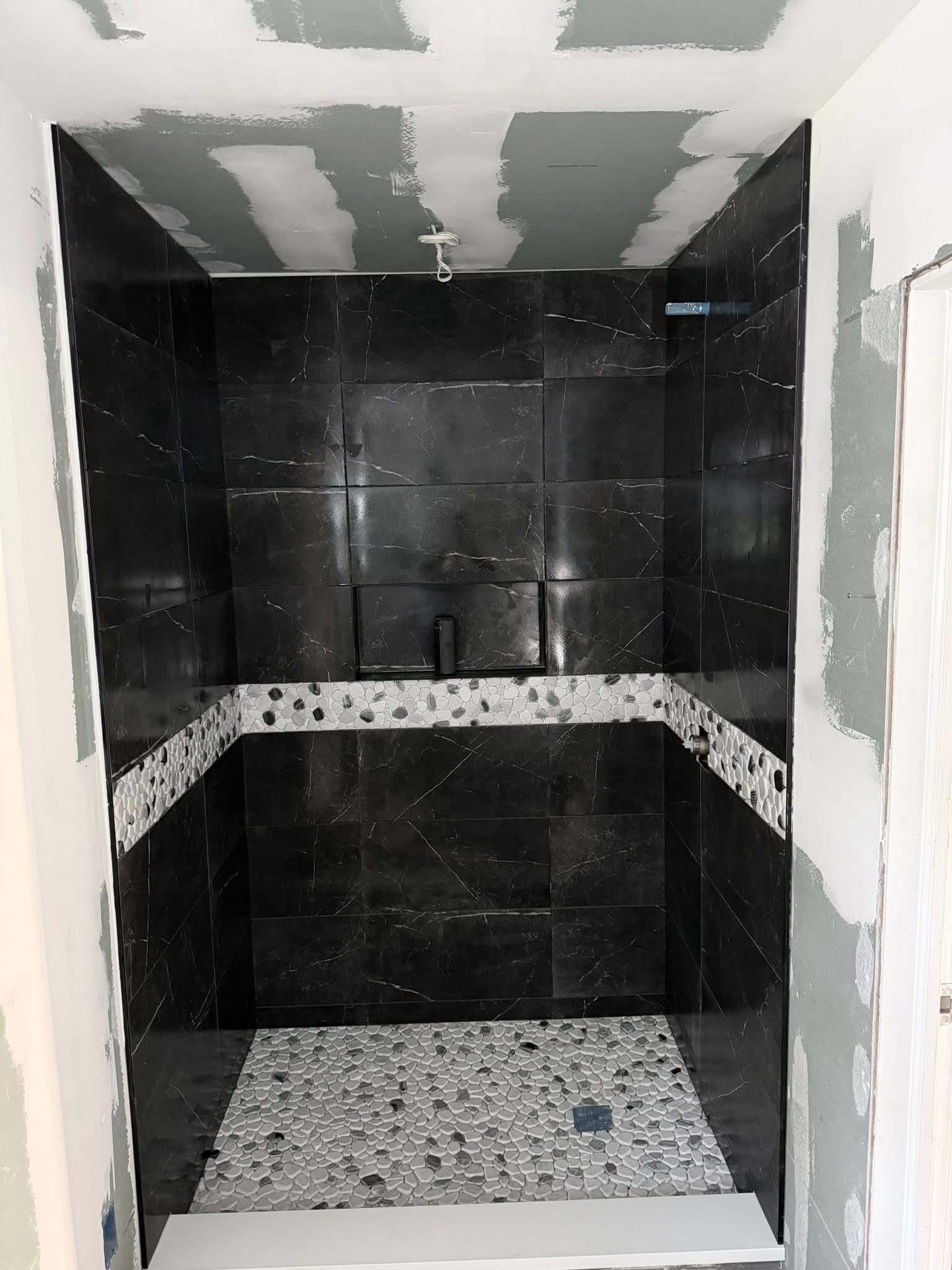 Black marble wall tile tiled with pebble accent